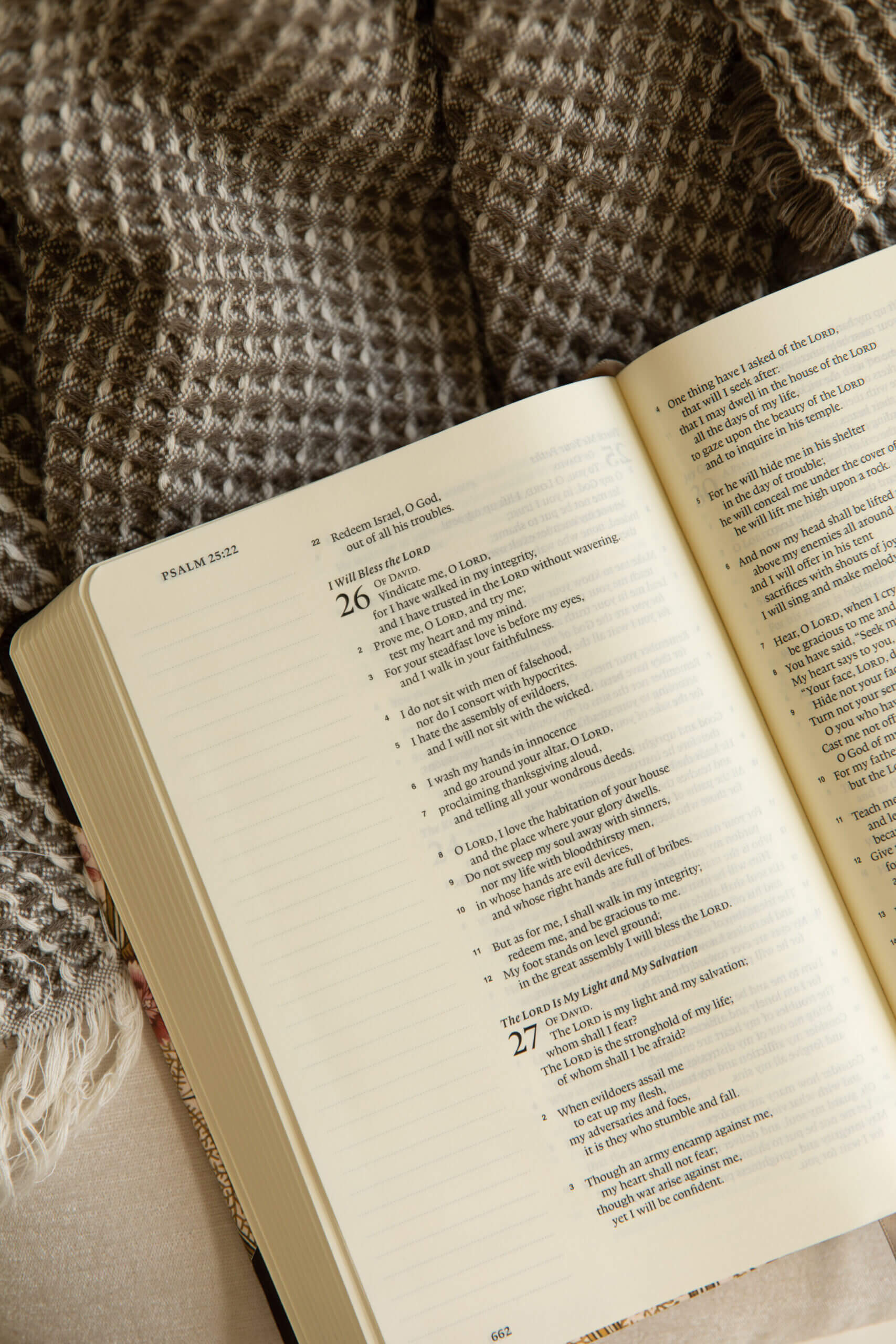 Bible opened to Psalm 26 laying on greige throw blanket